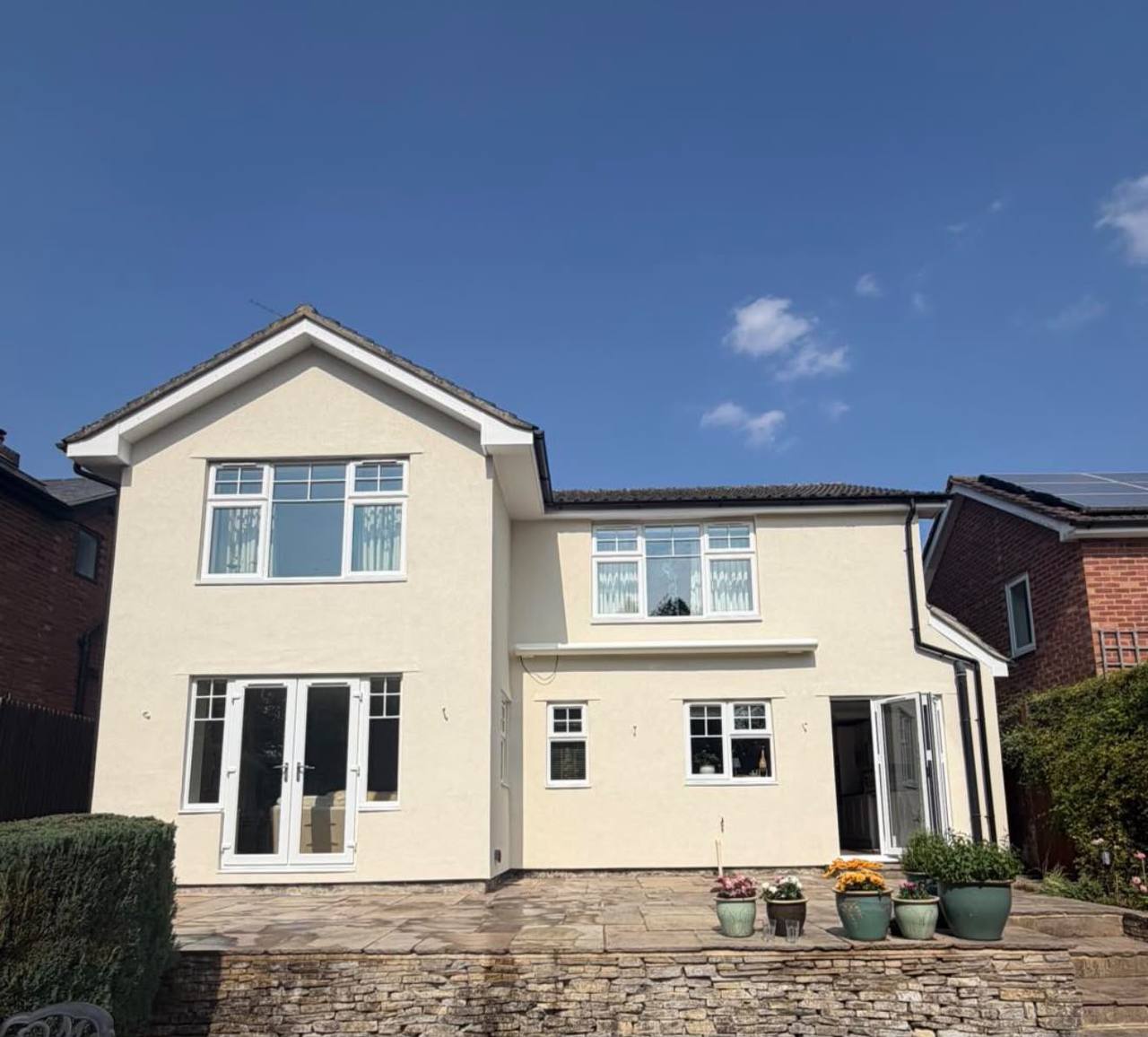 After: the same house finished in smooth cream silicone render