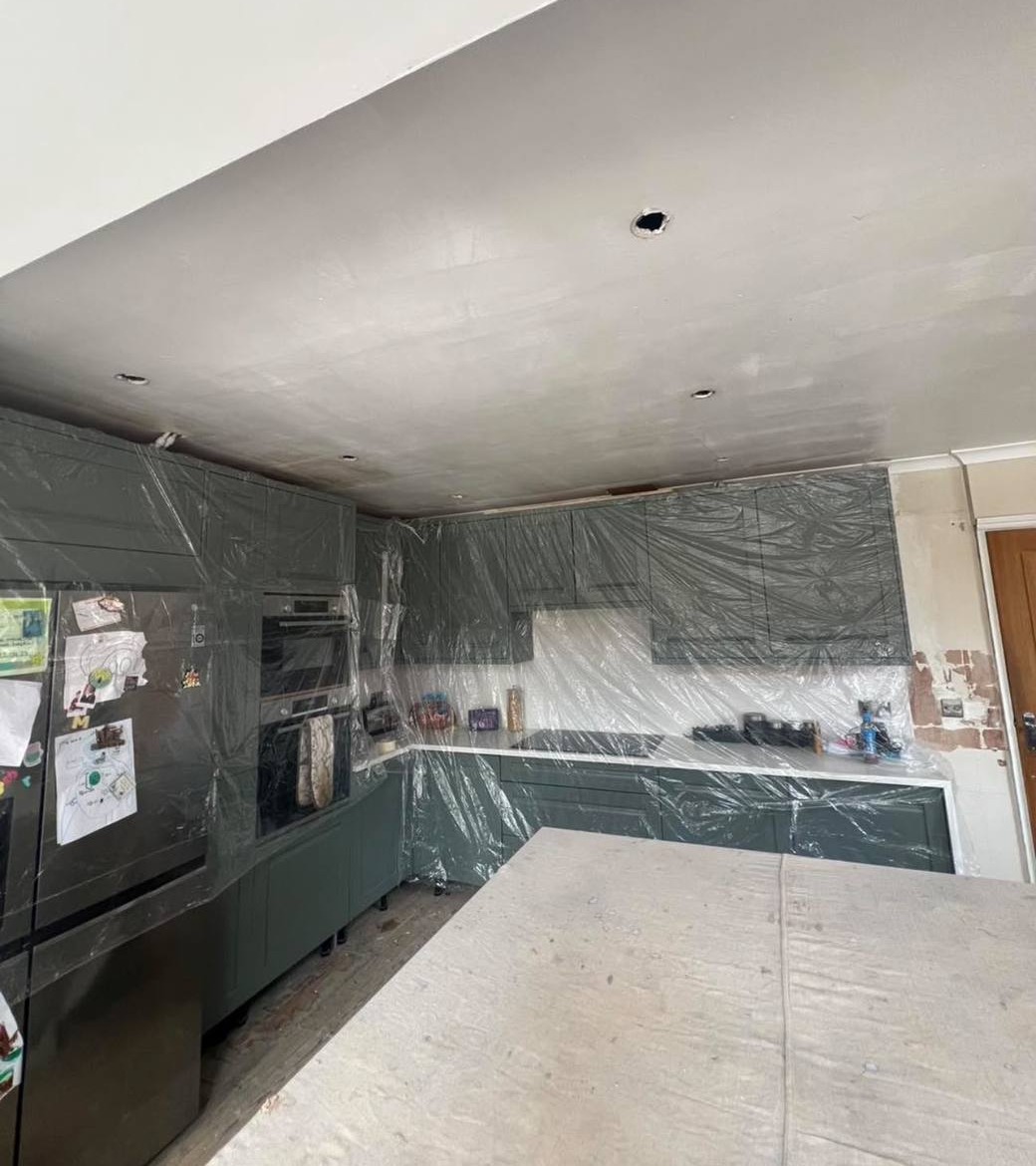 Before: a kitchen ceiling, units sheeted up, ready for plastering